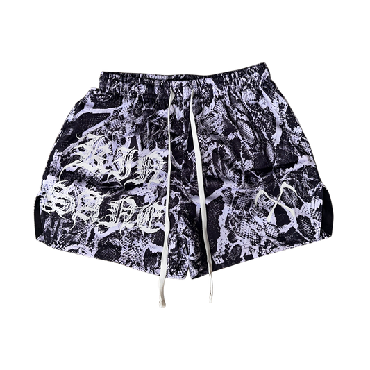 White and black snakeskin pattern athletic shorts with white drawstrings and white lettering on the right leg reading “KINSANE” and one white logo on the left leg 