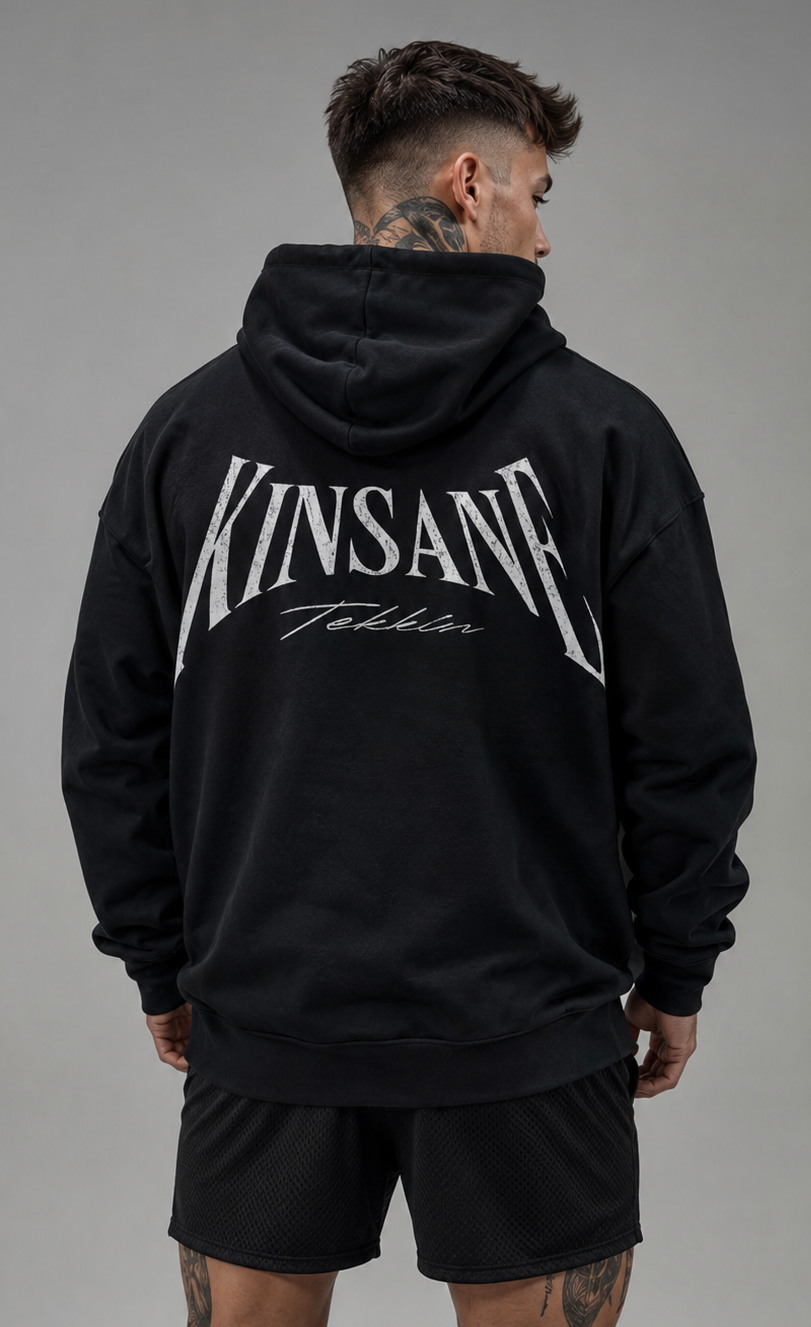 Back view of a man wearing a black hoodie with white text reading “KINSANE TEKKIN” 