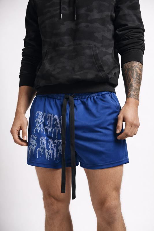 Man wearing Navy blue athletic shorts with elastic waistband and black drawstrings and blue lettering reading “KINSANE” on the right leg 
