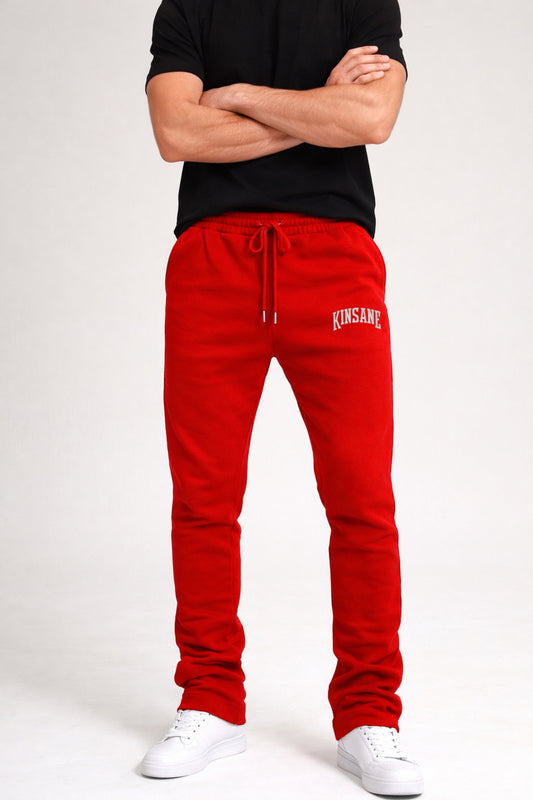 Guy wearing red stacked sweatpants with white lettering reading “KINSANE” on the right side 