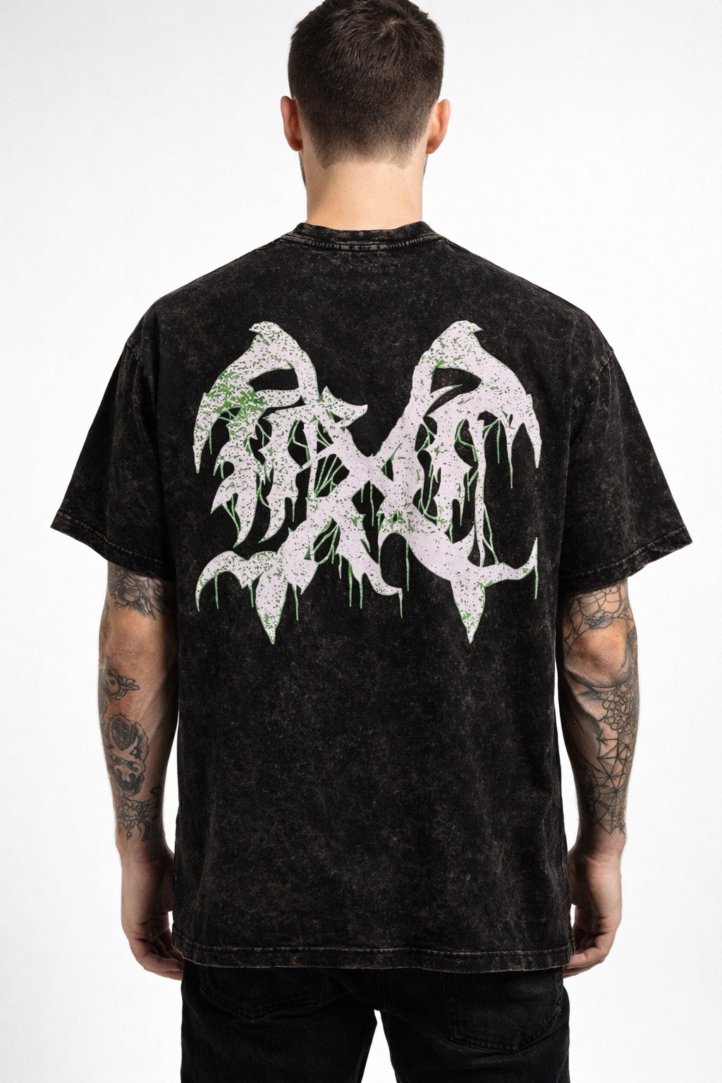 Back view of a man wearing a black acid washed t-shirt with a white and green logo 