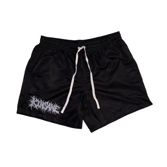 Black trunks with white drawstrings with tribal lettering reading “KINSANE” on the right leg 