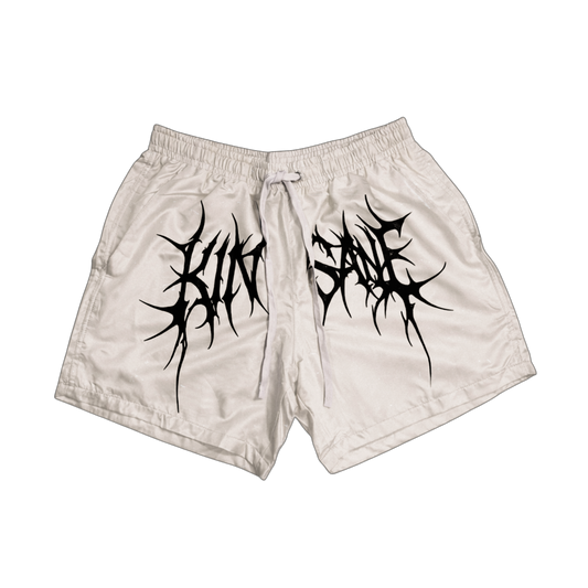 White trunks with white drawstrings and black tribal lettering across the middle reading “KINSANE” 