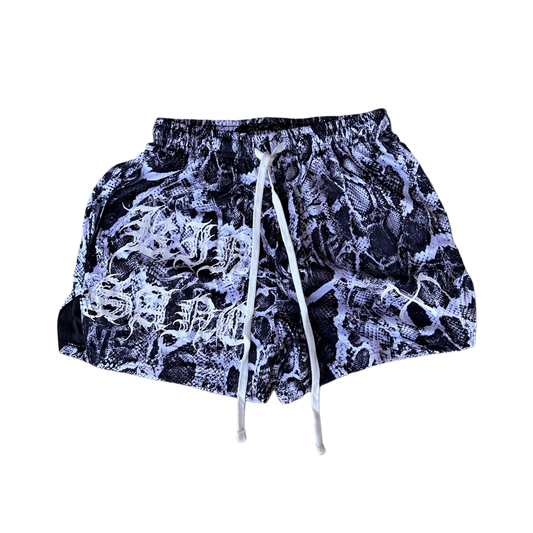 White and black snakeskin pattern athletic shorts with white drawstrings and white lettering on the right leg reading “KINSANE” and one white logo on the left leg 