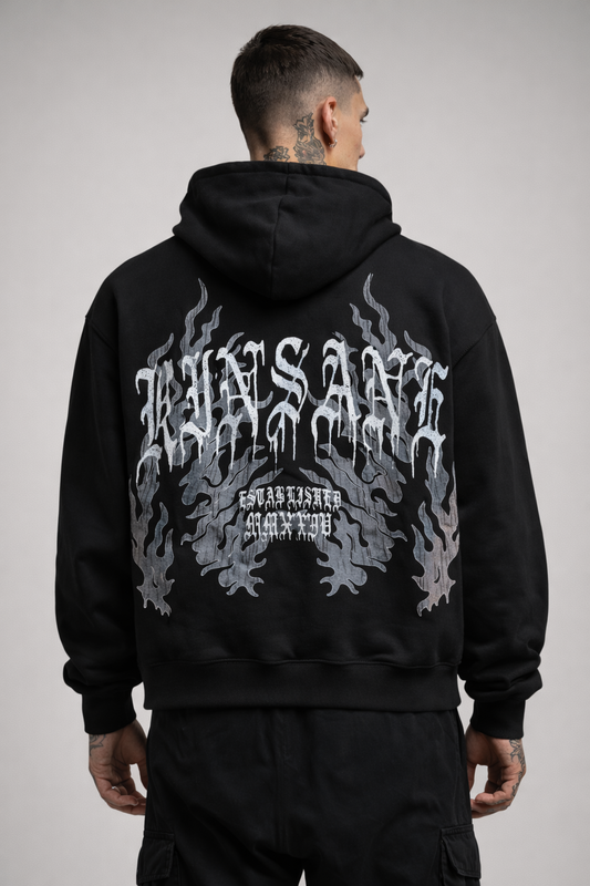Back view of a man wearing a black hoodie with grey blue flames and white text reading “KINSANE ESTABLISHED MMXXIV” 