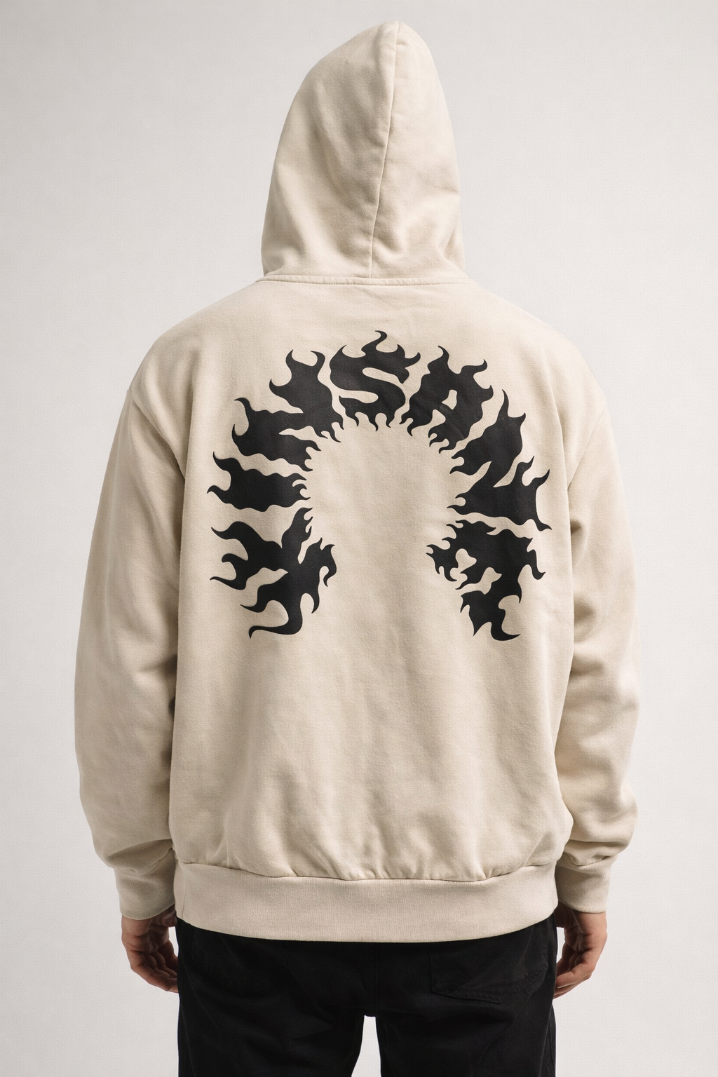 Back view of man wearing a beige hoodie with black flame lettering reading “KINSANE” 