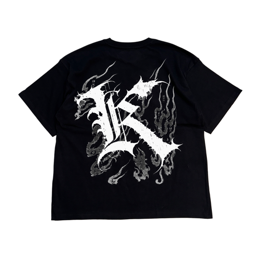 Back view of a black T-shirt with a white logo displaying white Japanese style flames and a white letter “K” and various Japanese text 