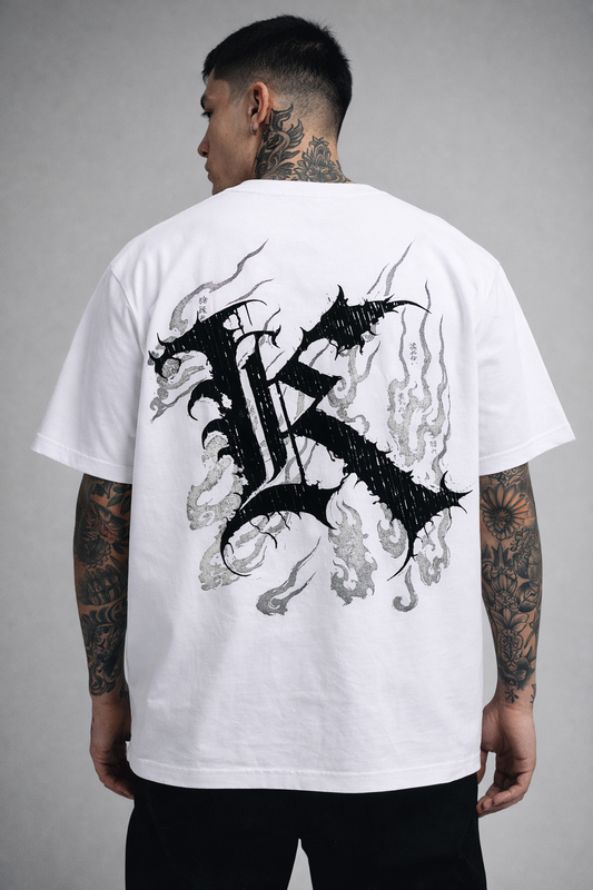 Back view of man wearing a white T-shirt with a black logo displaying black Japanese style flames and a black letter “K” and various Japanese text 