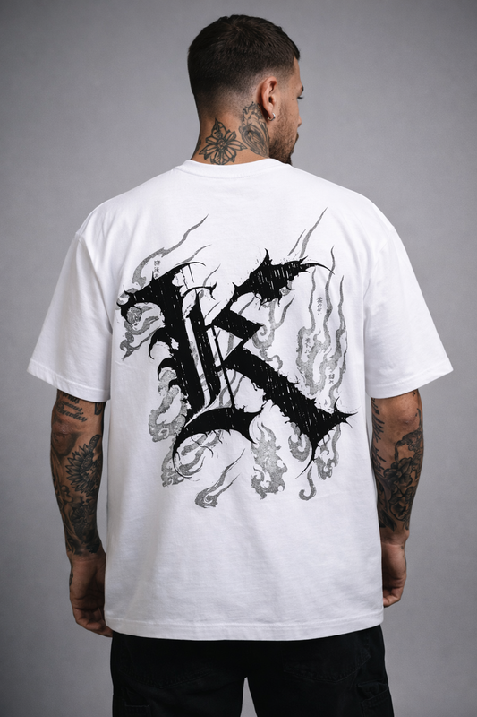 Back view of man wearing a white T-shirt with a black logo displaying black Japanese style flames and a black letter “K” and various Japanese text 