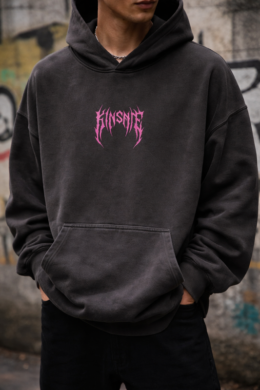 Guy wearing Dark gray hoodie with pink tribal lettering reading “KINSANE” in the center 