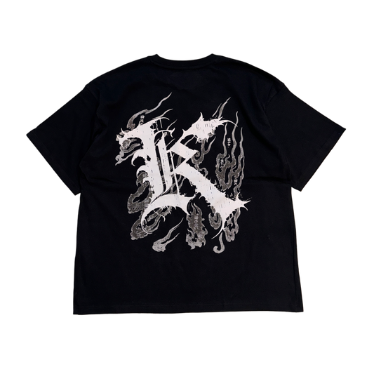 Back view of a black T-shirt with a white logo displaying white Japanese style flames and a white letter “K” and various Japanese text 