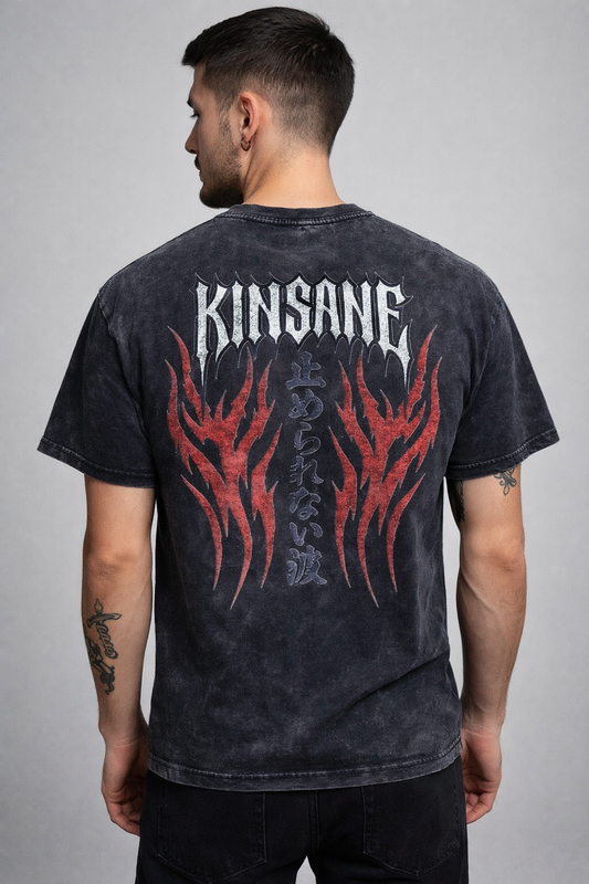 Back view of a man wearing a black acid washed t-shirt with red flames and white spiked lettering reading “KINSANE” and black Japanese lettering translating to “UNSTOPPABLE FLAME” 