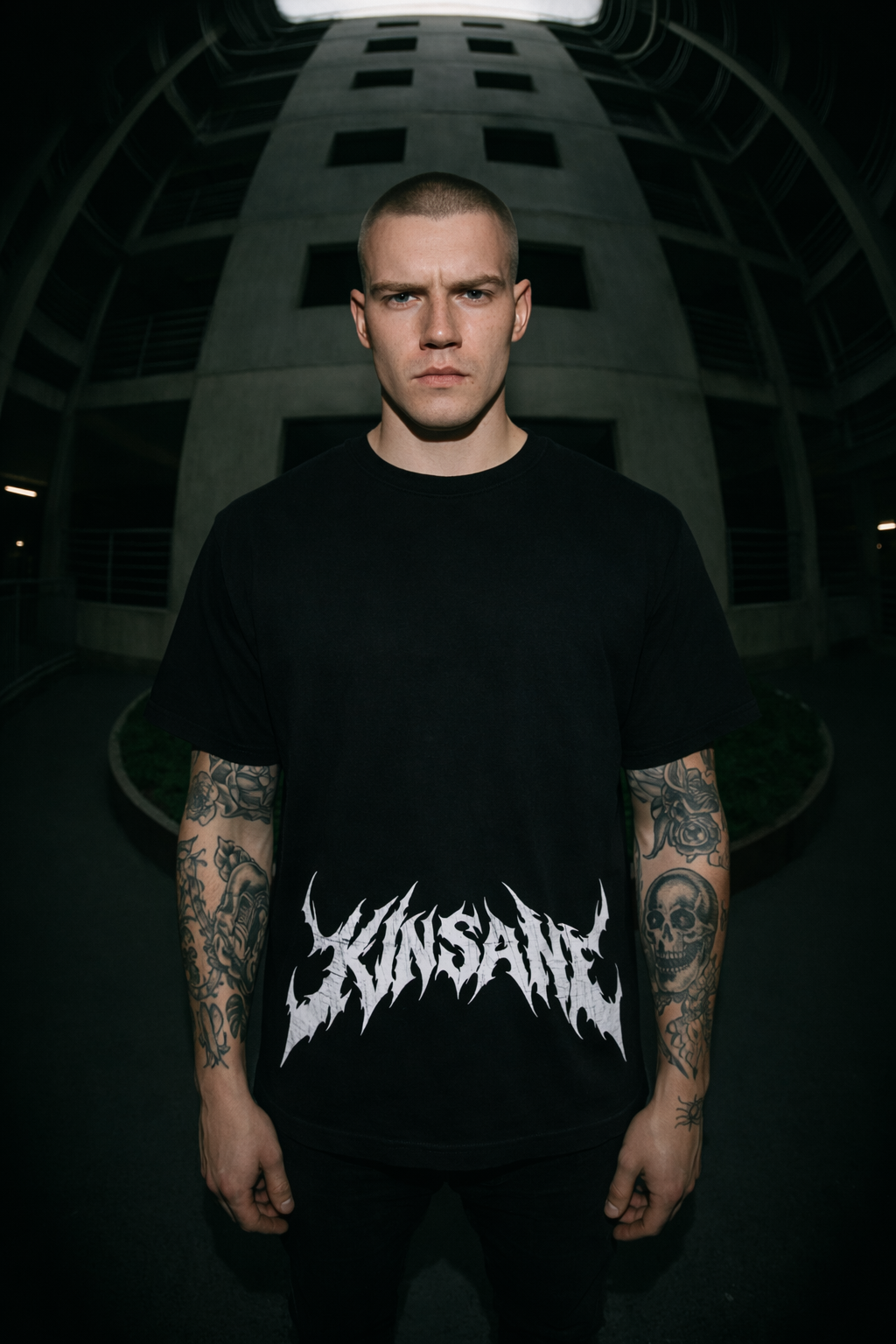 Man wearing a Black t shirt with white text reading “KINSANE” 