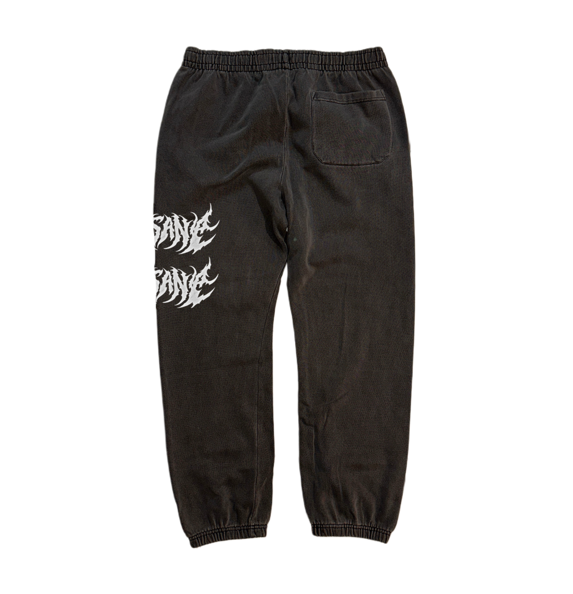Back view of grey vintage cuffed joggers with white text reading “sane” on the back left leg 