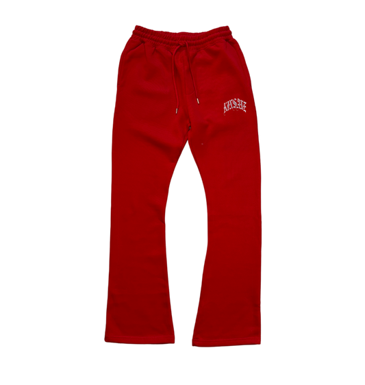 Red stacked sweatpants with white lettering reading “KINSANE” on the right side 